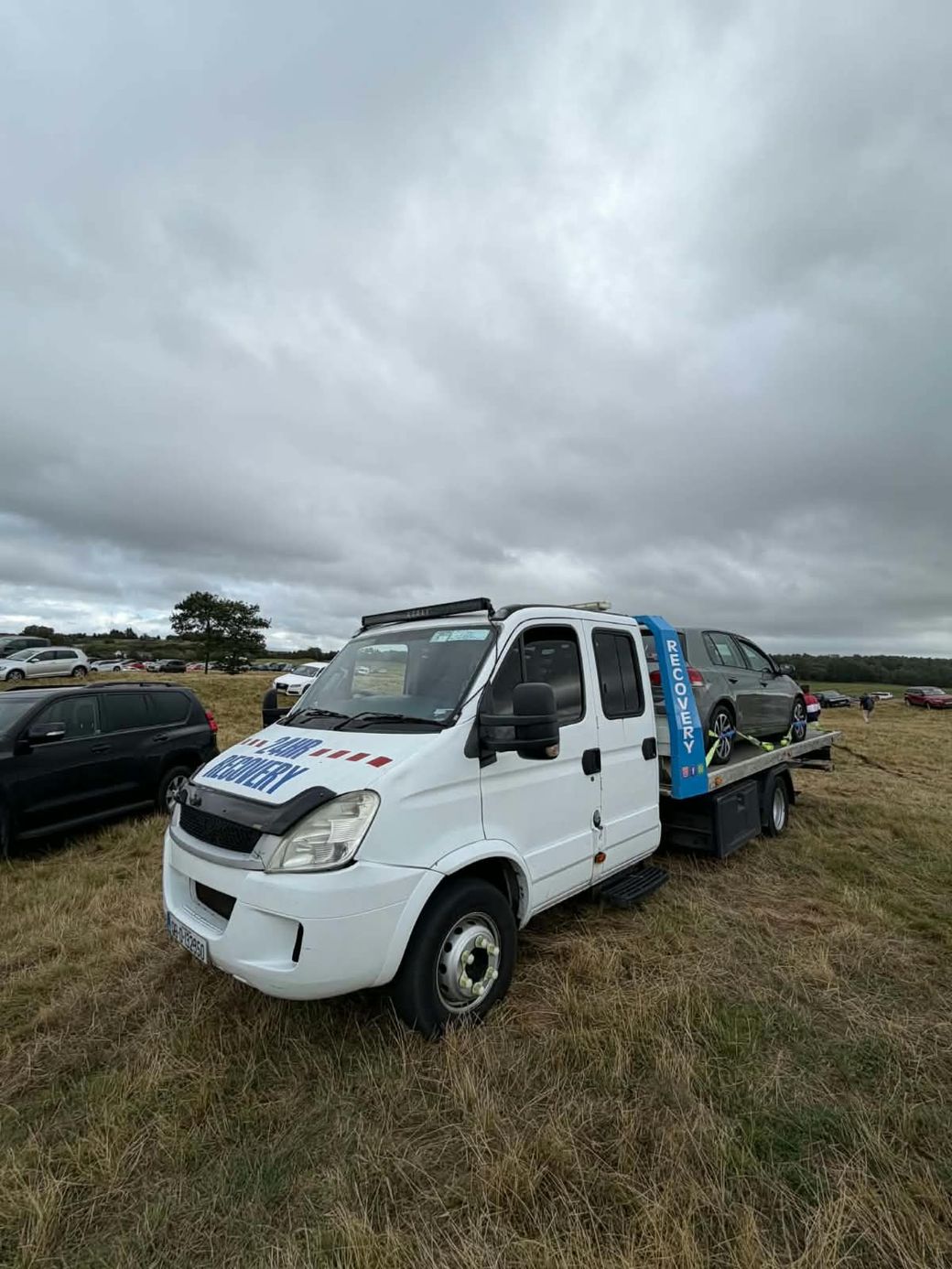 O'Driscoll's Recovery 24hr recovery truck in a field with a car loaded on the back